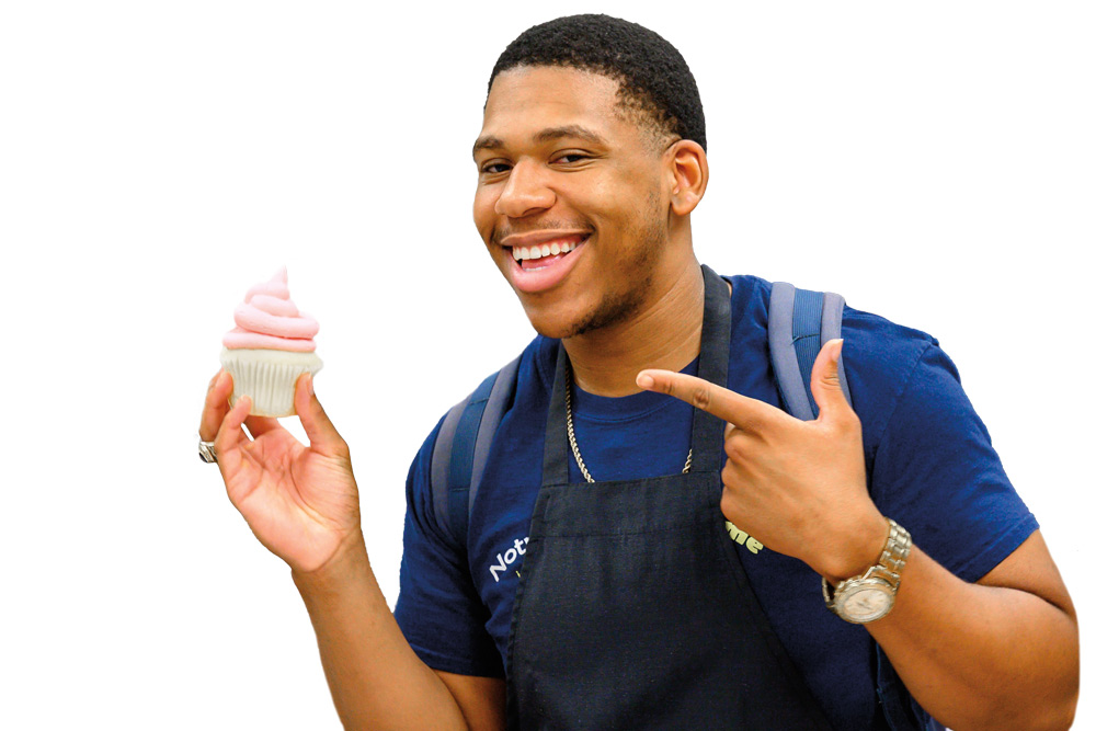 A student points at a cupcake