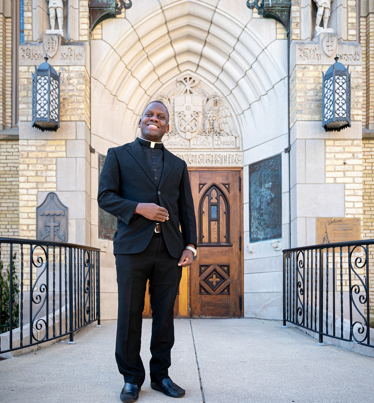 Fr. Arthur Ssembajja standing in front of chapple doors