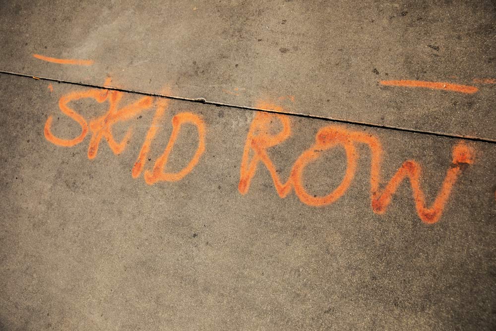 the words skid row spray painted on cement