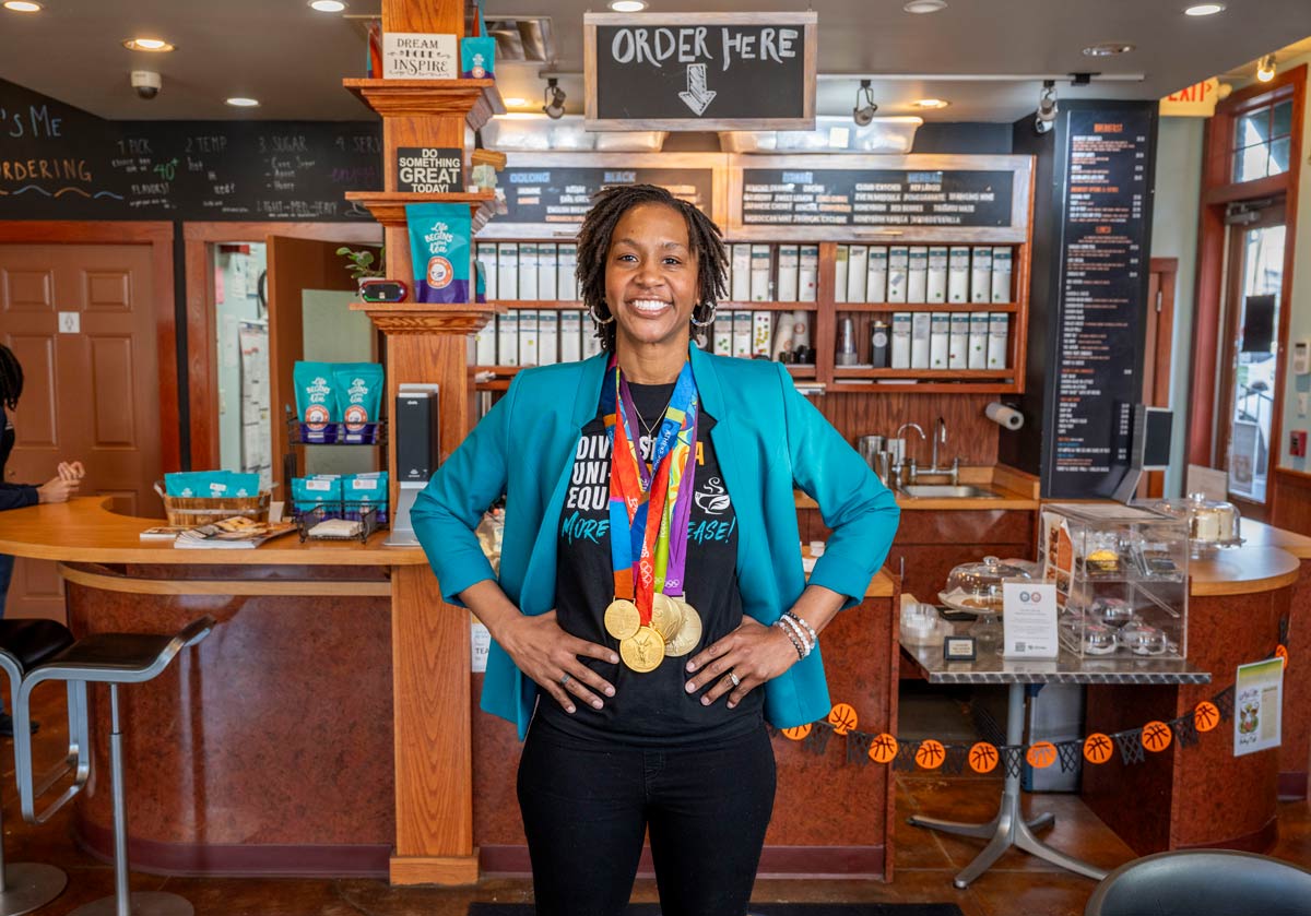 Tamika Catchings standing in her tea shop wearing her medals