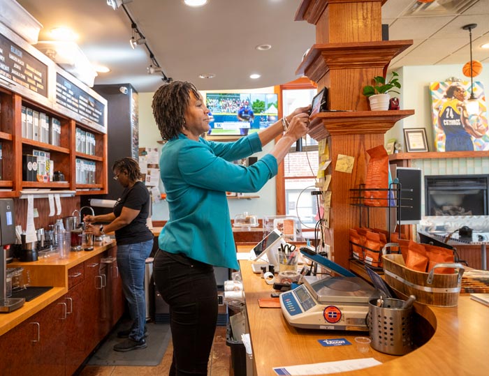 Tamika Catchings in her tea shop helping to make tea for a customer