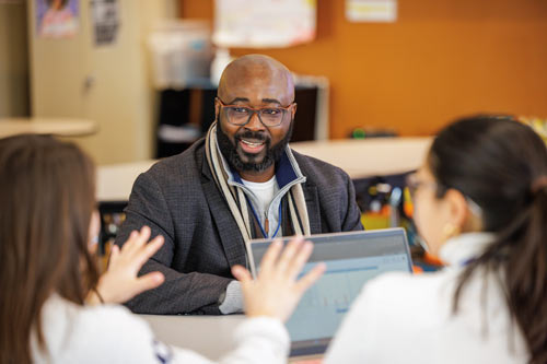 Fred Nwanganga works with students.